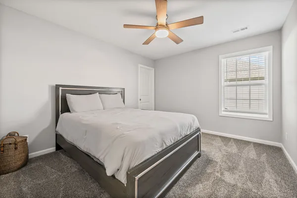 a bedroom with a bed and a ceiling fan
