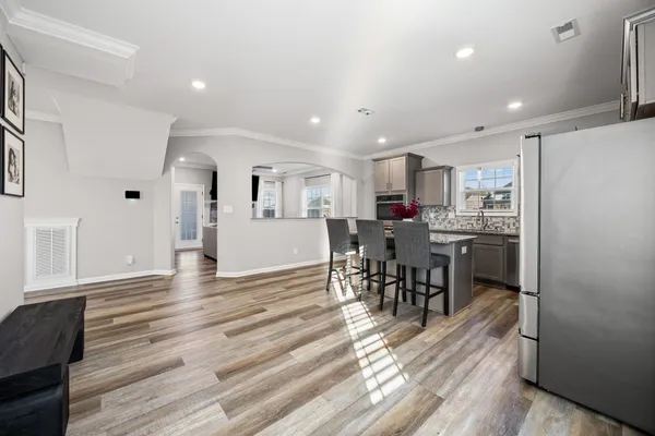 a kitchen with stainless steel appliances a refrigerator a stove a sink dishwasher with a dining table and chairs