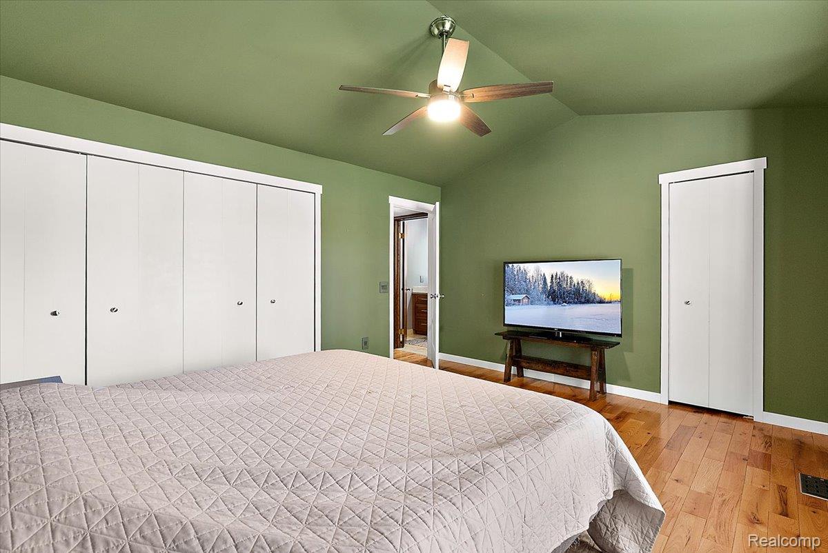 60718 Campground Road Washington, MI 48094 - Photo 21 of 37 Vaulted ceiling with a ceiling fan, wood-finish flooring, and ample closet space with bi-fold doors