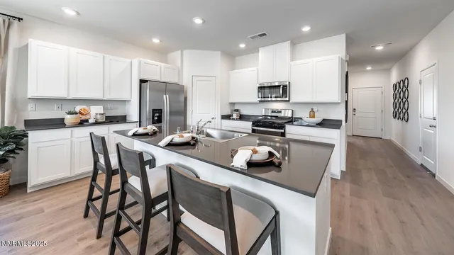 a kitchen with a dining table chairs refrigerator and microwave