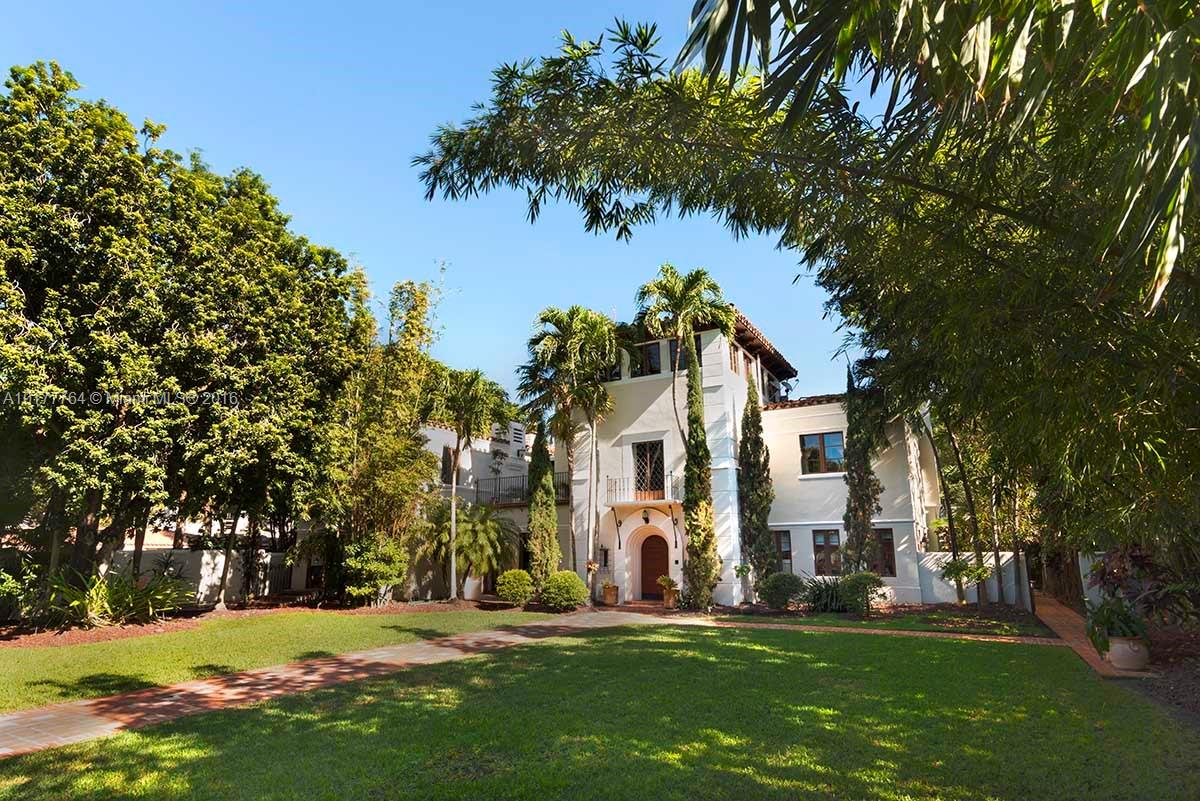 4855 Pine Tree Drive Miami Beach, FL 33140 - Photo 14 of 26 a view of a white house in front of a big yard with plants and large trees