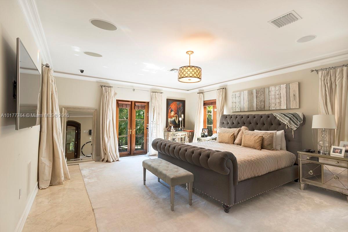 4855 Pine Tree Drive Miami Beach, FL 33140 - Photo 20 of 26 a spacious bedroom with a bed and glass window