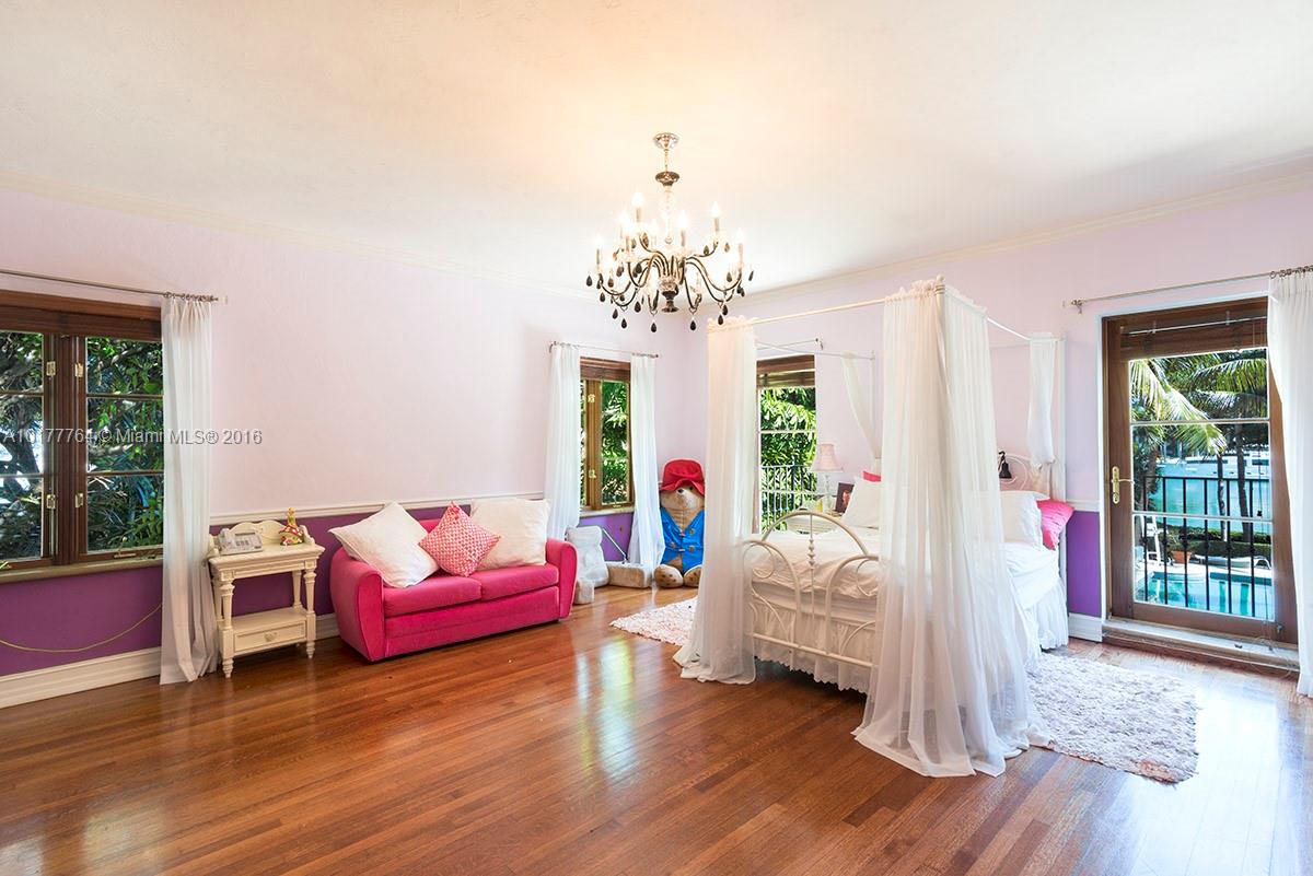 4855 Pine Tree Drive Miami Beach, FL 33140 - Photo 22 of 26 a living room with furniture and a chandelier