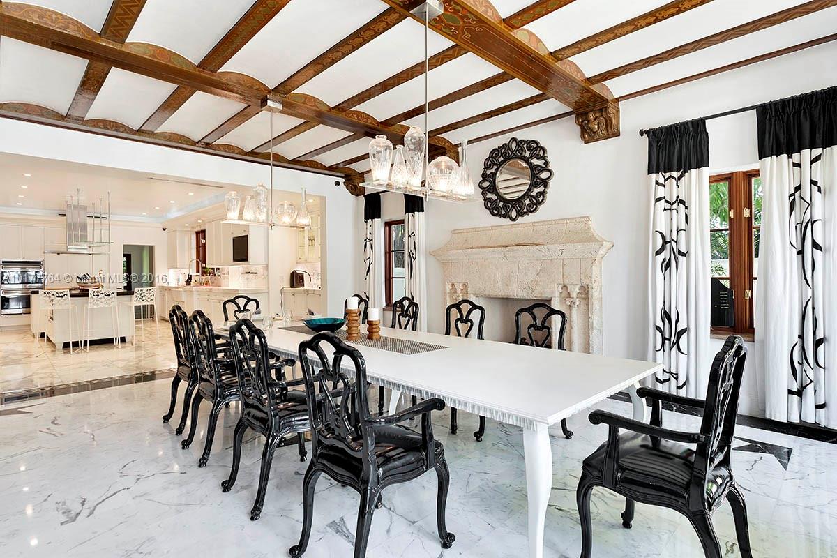 4855 Pine Tree Drive Miami Beach, FL 33140 - Photo 10 of 26 a view of a dining area with furniture and a fireplace