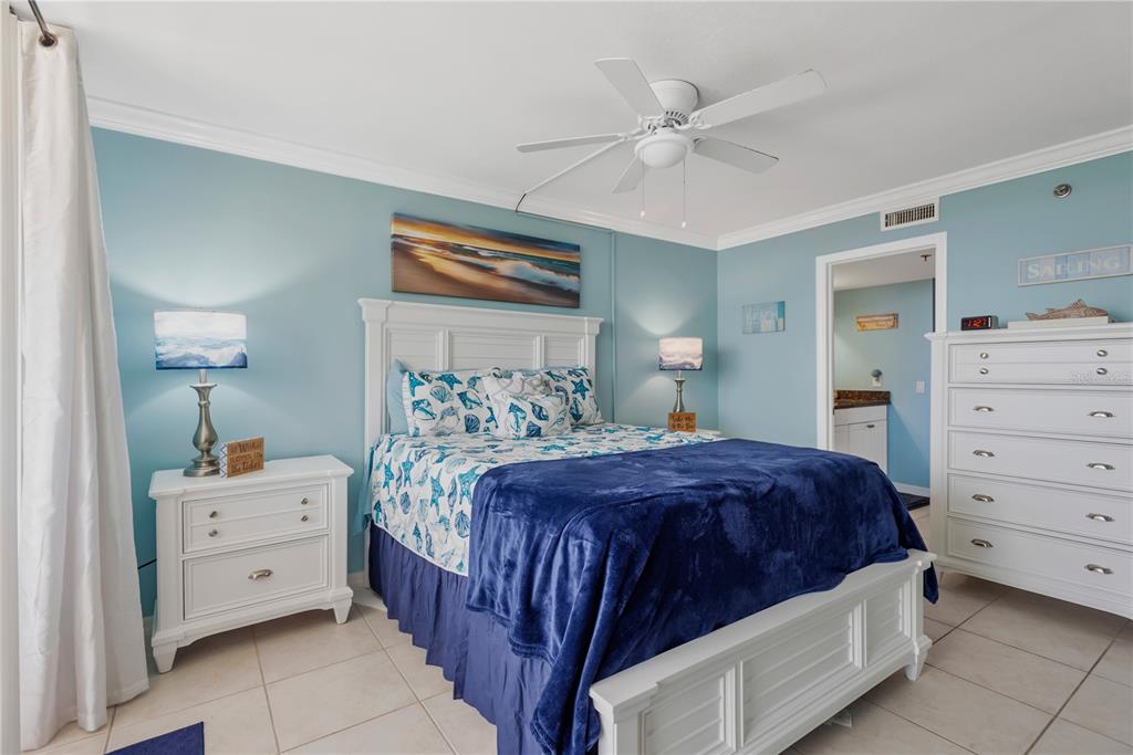 6009 Sea Ranch Drive, Unit 303 Hudson, FL 34667 - Photo 11 of 48 a bedroom with a bed and a chandelier