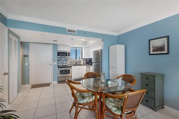 a kitchen with stainless steel appliances kitchen island granite countertop a dining table and chairs
