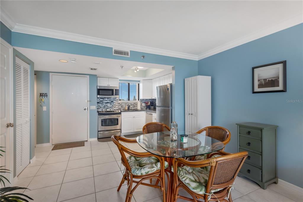 6009 Sea Ranch Drive, Unit 303 Hudson, FL 34667 - Photo 17 of 48 a kitchen with stainless steel appliances kitchen island granite countertop a dining table and chairs