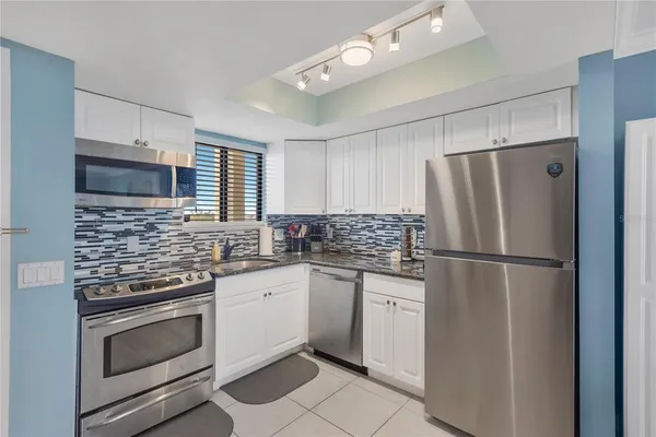 a kitchen with cabinets stainless steel appliances and sink