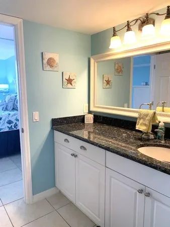 a bathroom with a granite countertop sink and a mirror