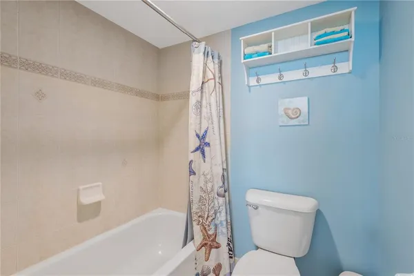 a bathroom with a toilet and a shower curtain