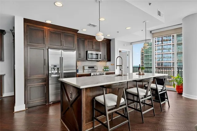 a kitchen with a sink a refrigerator and a stove top oven