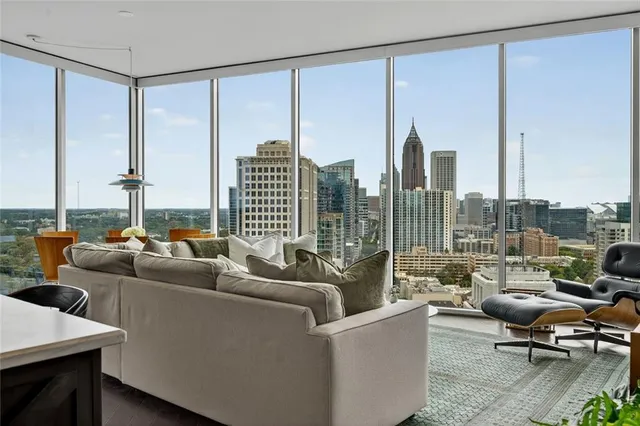 a living room with furniture city view and large windows