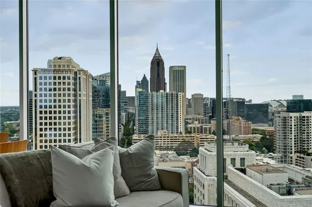 a living room with furniture a flat screen tv and a large window