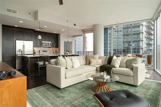 a kitchen with stainless steel appliances a dining table chairs refrigerator and sink