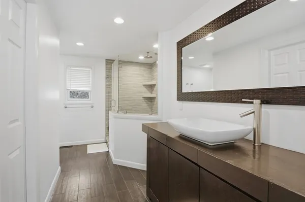 a bathroom with a sink a mirror and a shower