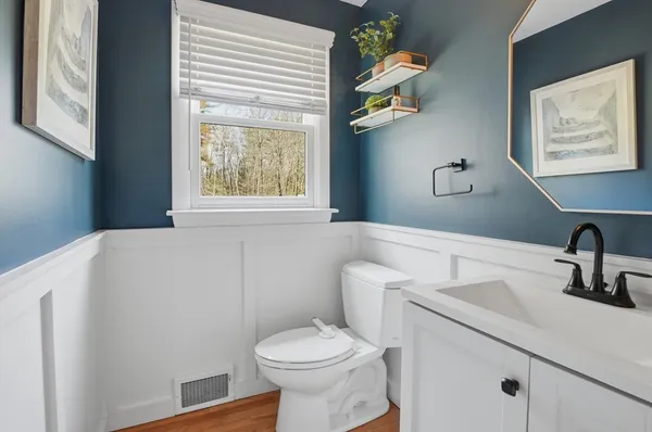 a bathroom with a toilet a sink and mirror