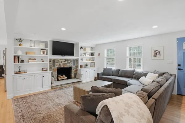 a living room with furniture a fireplace and a flat screen tv