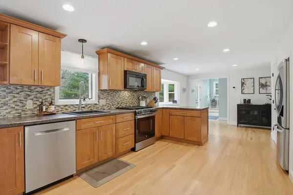 a large kitchen with stainless steel appliances granite countertop a sink and cabinets