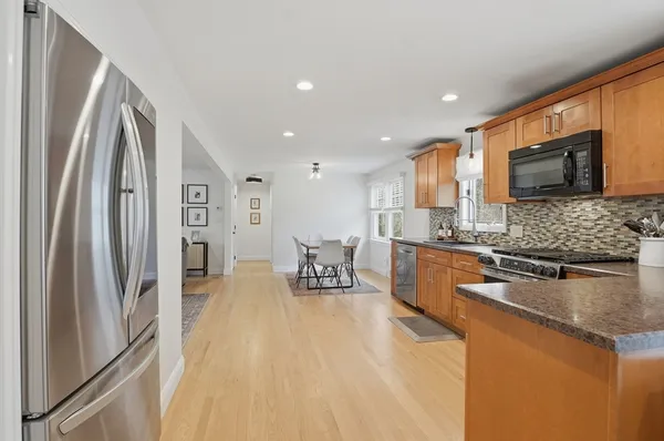 a kitchen with stainless steel appliances granite countertop a refrigerator a stove top oven a sink and dishwasher