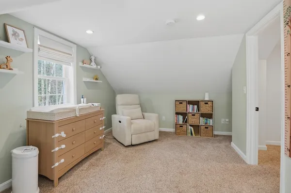 a living room with furniture and a baby crib