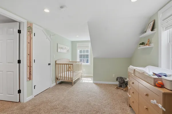 a room with a baby crib and a dresser