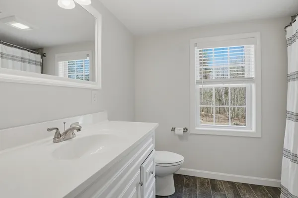 a bathroom with a sink a toilet and a window