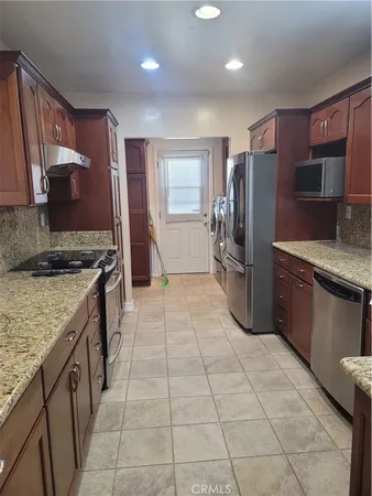a kitchen with stainless steel appliances granite countertop a refrigerator stove and sink
