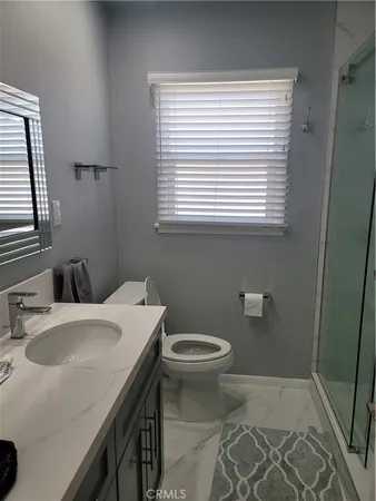a bathroom with a sink a toilet and a window