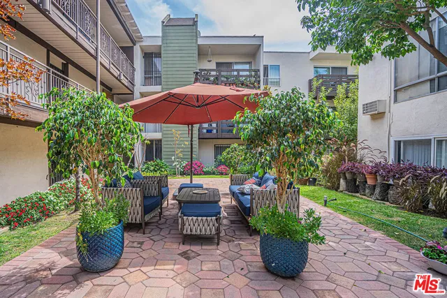 a view of a chair and table in backyard with a garden