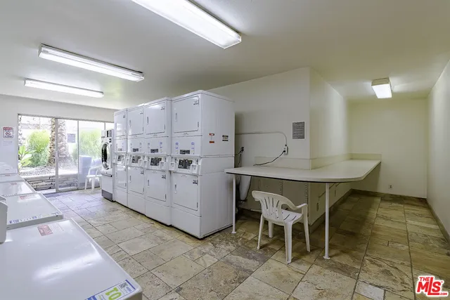 a kitchen with furniture a refrigerator and a table