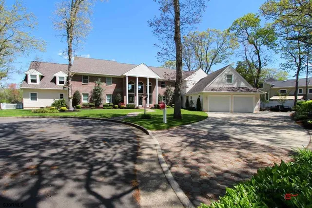a front view of a house with a yard and trees