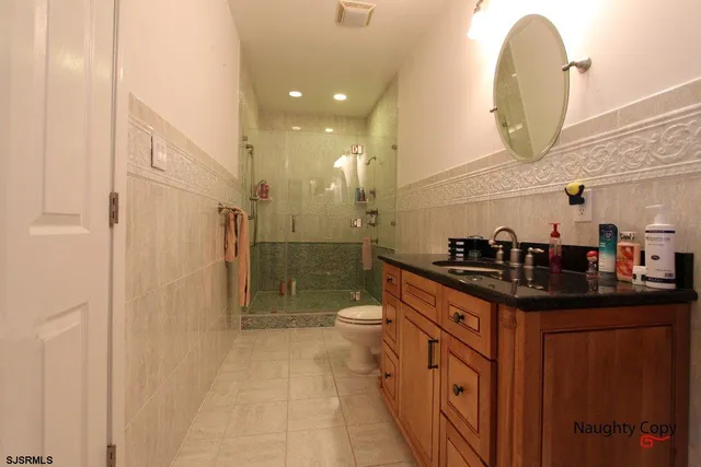 a spacious bathroom with a granite countertop sink a toilet and a mirror