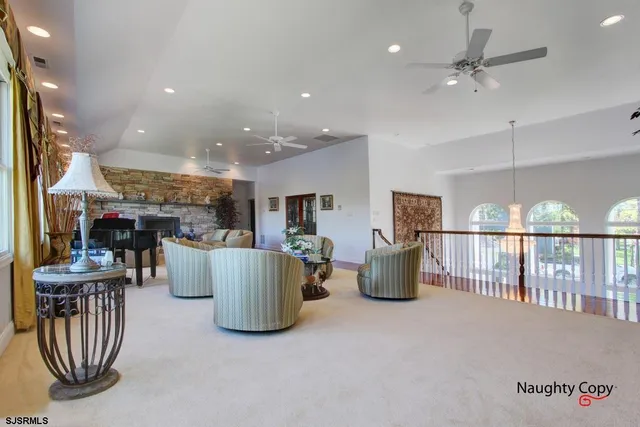 a living room with furniture a flat screen tv and a chandelier