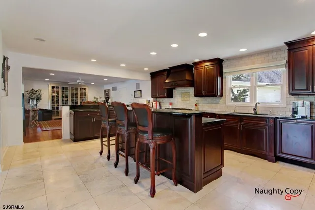 a kitchen with stainless steel appliances kitchen island granite countertop a refrigerator and a sink