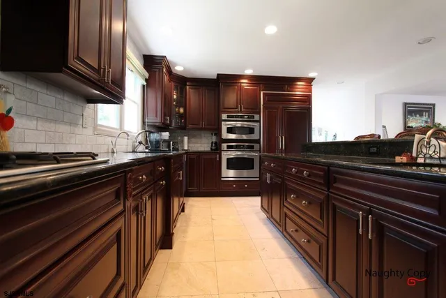 a kitchen with wooden cabinets and a stove top oven