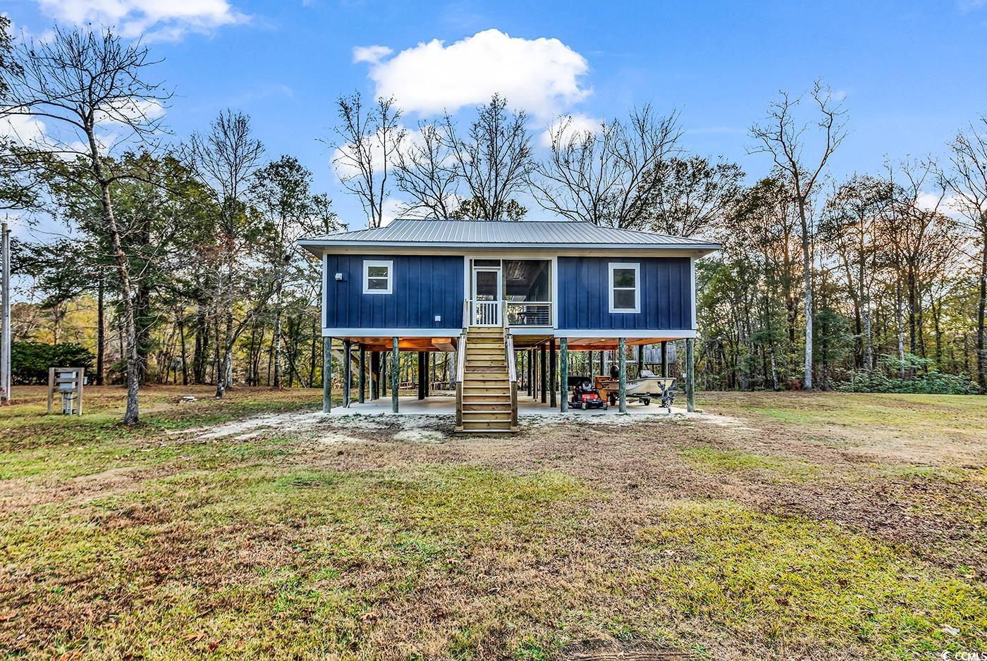 32 Old Place Kingstree, SC 29556 - Photo 29 of 40 Raised beach house featuring stairway, a patio, a front lawn, and a metal roof