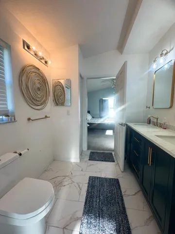 a bathroom with a toilet a sink and mirror
