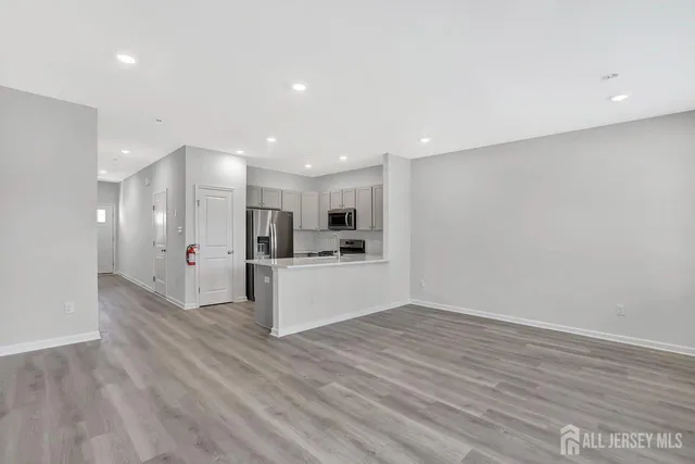 a view of kitchen with kitchen island white cabinets and wooden floor
