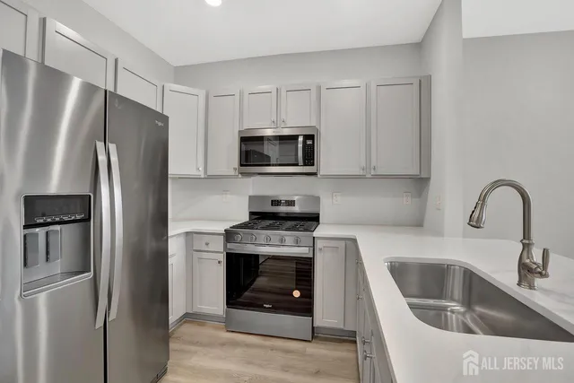 a kitchen with stainless steel appliances granite countertop a refrigerator stove and sink