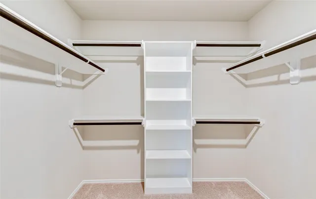 a view of walk in closet with empty racks