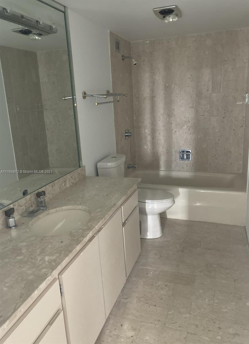 1800 Northeast 114th Street, Unit 703 Miami, FL 33181 - Photo 12 of 33 a bathroom with a granite countertop sink a toilet a mirror and bathtub