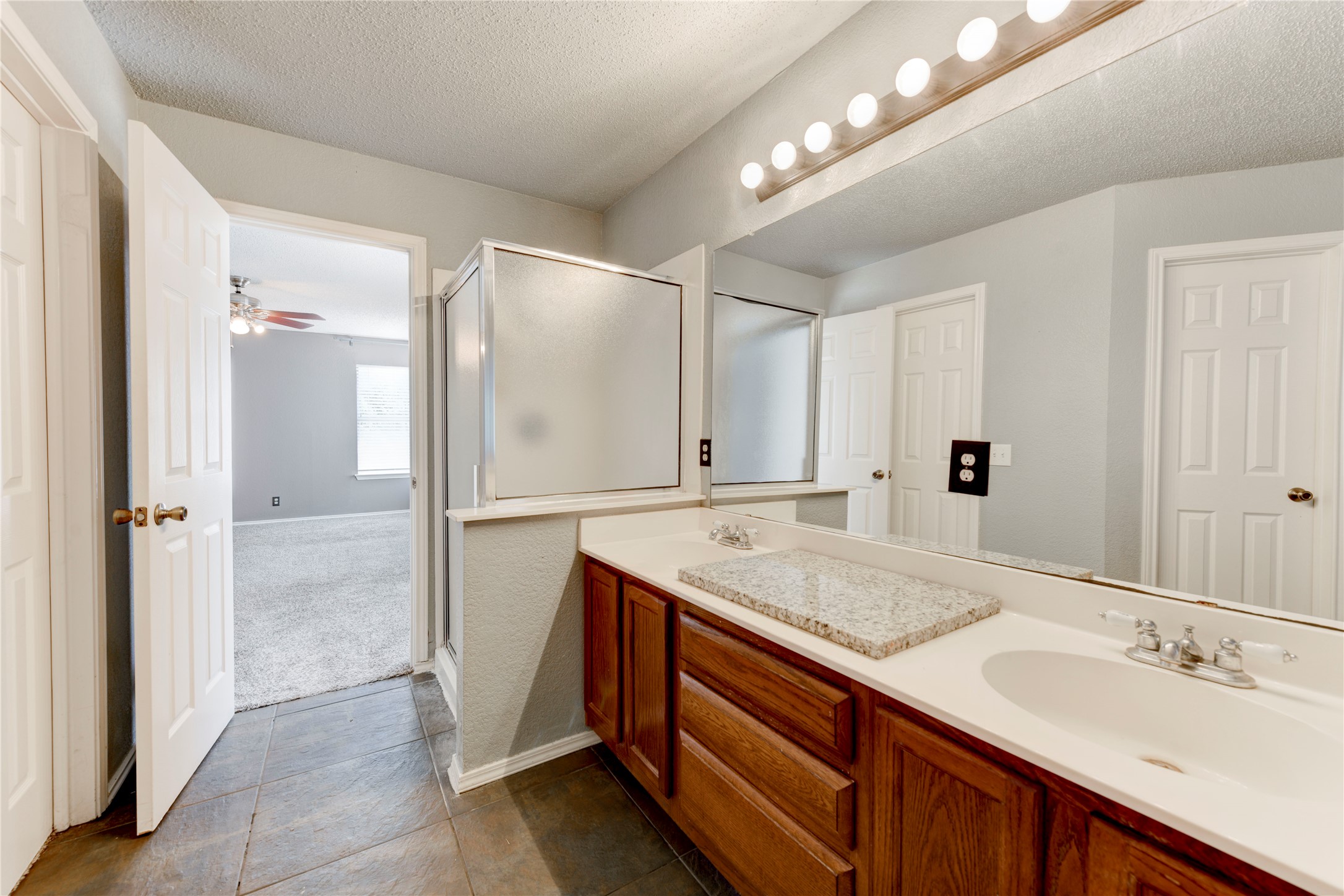 16913 Langland Road Pflugerville, TX 78660 - Photo 9 of 18 A spacious vanity area with wooden cabinetry connects seamlessly to the main suite.