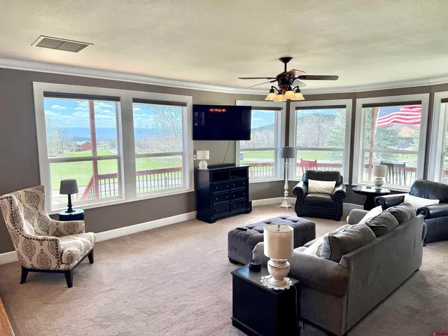 a living room with furniture a flat screen tv and a large window