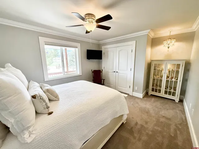 a spacious bedroom with a bed and a ceiling fan
