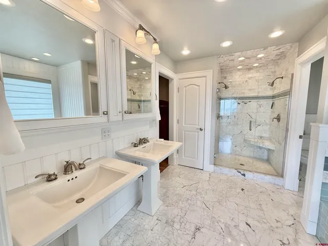 a bathroom with a bathtub shower sink and mirror