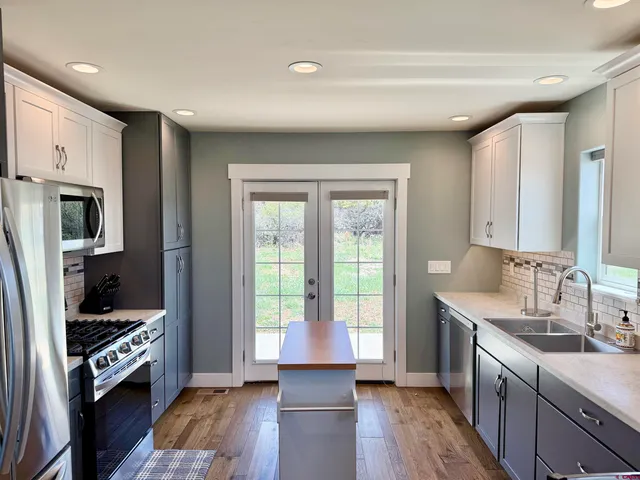 a kitchen with stainless steel appliances granite countertop a refrigerator stove microwave and sink