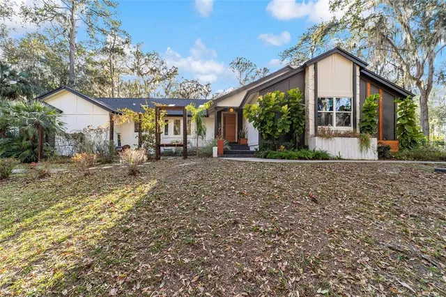 a vase of flowers sitting on a floor in front of a door