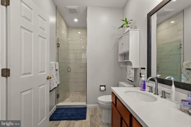 a bathroom with a sink a toilet a shower and a mirror