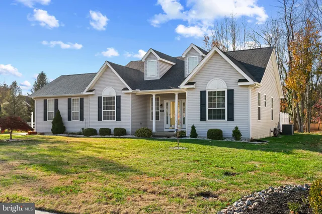a view of a white house with a big yard and potted plants