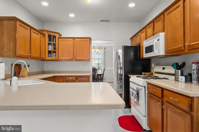 a kitchen with stainless steel appliances granite countertop a sink a stove and a refrigerator